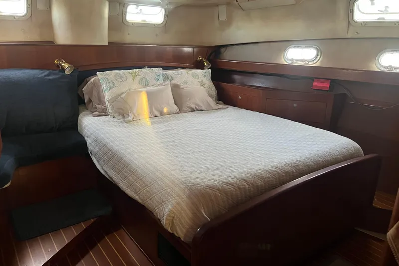 Pelagia Yacht Photos Pics Cozy cabin interior of 1998 Hunter Passage 450 yacht with comfortable bed and wooden furnishings.