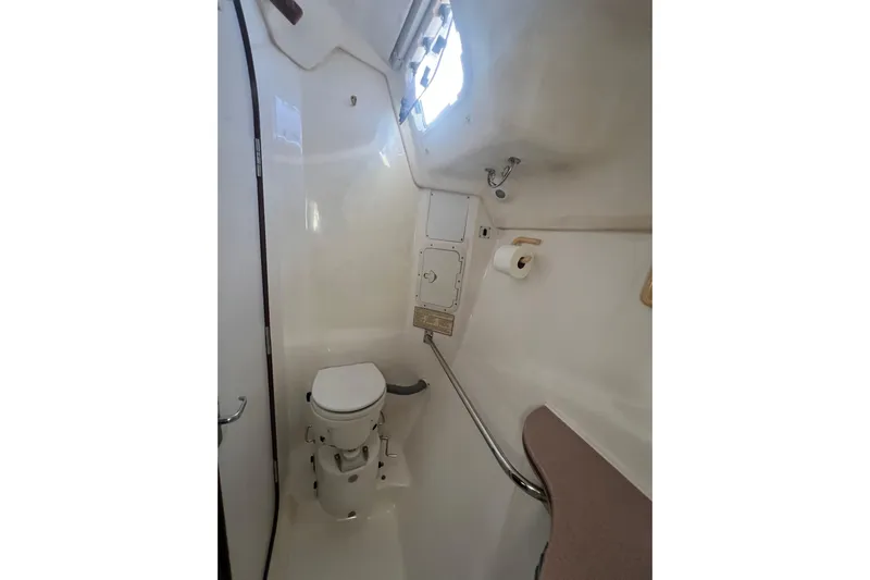 Pelagia Yacht Photos Pics 1998 Hunter Passage 450 yacht bathroom with toilet, window, and storage.