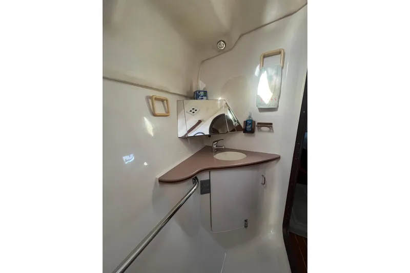 Pelagia Yacht Photos Pics 1998 Hunter Passage 450 yacht bathroom with sink, mirror, and storage cabinet.