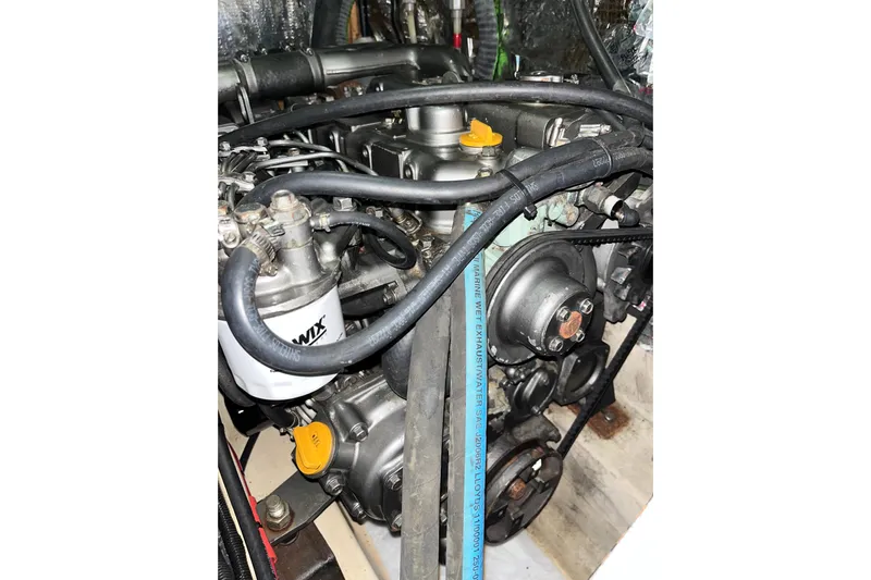 Pelagia Yacht Photos Pics Engine compartment of a 1998 Hunter Passage 450 sailboat, showcasing mechanical components and hoses.