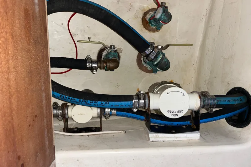 Pelagia Yacht Photos Pics Bilge pump system in a 1998 Hunter Passage 450 sailboat, featuring hoses and valves.