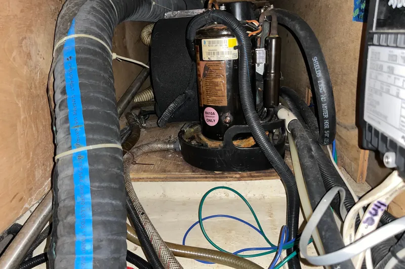 Pelagia Yacht Photos Pics Engine compartment of a 1998 Hunter Passage 450 sailboat, showing hoses and mechanical components.