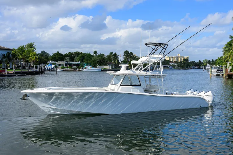 Denied Yacht Photos Pics 2021 Yellowfin 42 boat on a calm waterway under a partly cloudy sky.