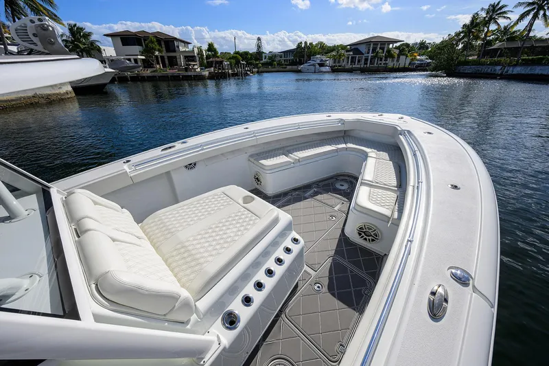 Denied Yacht Photos Pics 2021 Yellowfin 42 boat with luxurious seating on a calm waterfront.