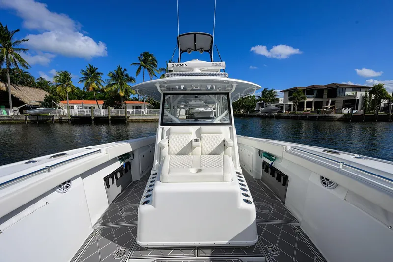 Denied Yacht Photos Pics 2021 Yellowfin 42 boat with sleek design, docked near waterfront homes and palm trees.