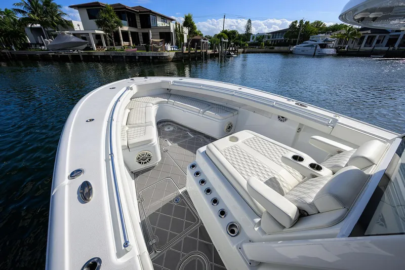 Denied Yacht Photos Pics 2021 Yellowfin 42 boat with luxurious seating, docked near waterfront homes.
