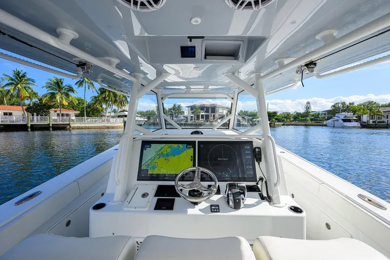 Denied Yacht Photos Pics 2021 Yellowfin 42 boat cockpit with advanced navigation system, steering wheel, and waterfront view.