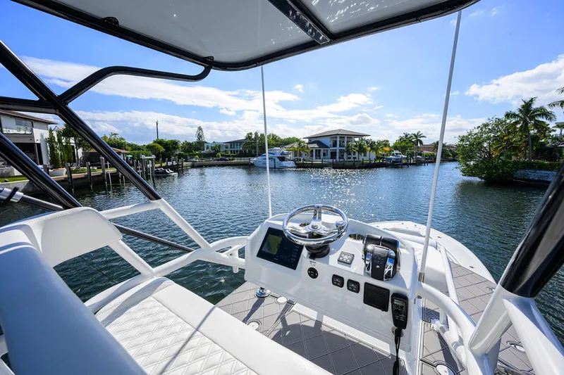 Denied Yacht Photos Pics 2021 Yellowfin 42 boat helm with waterfront view, clear skies, and modern controls.
