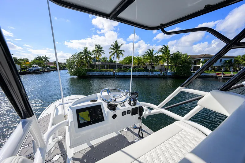 Denied Yacht Photos Pics 2021 Yellowfin 42 boat interior with steering console, on a sunny day by the water.