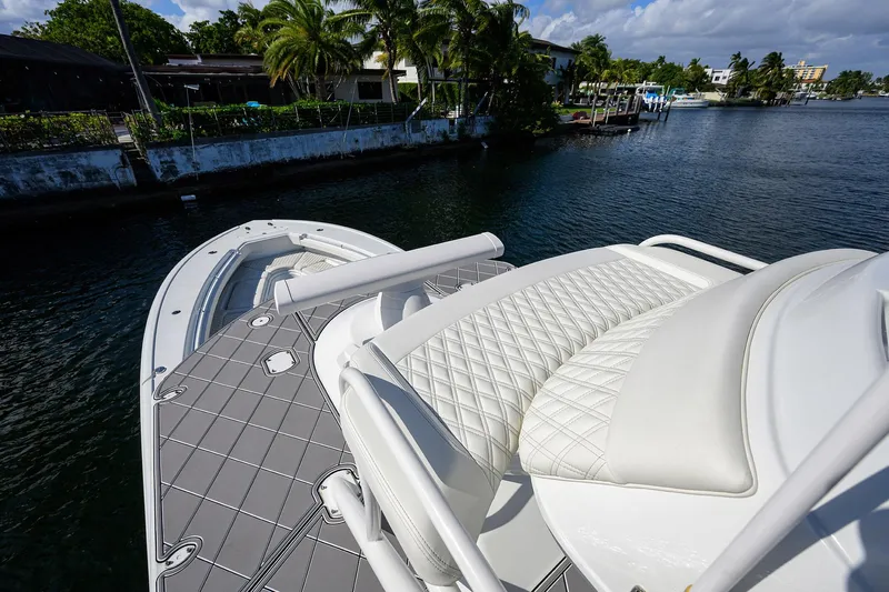Denied Yacht Photos Pics 2021 Yellowfin 42 boat with luxurious seating, docked near lush waterfront homes.
