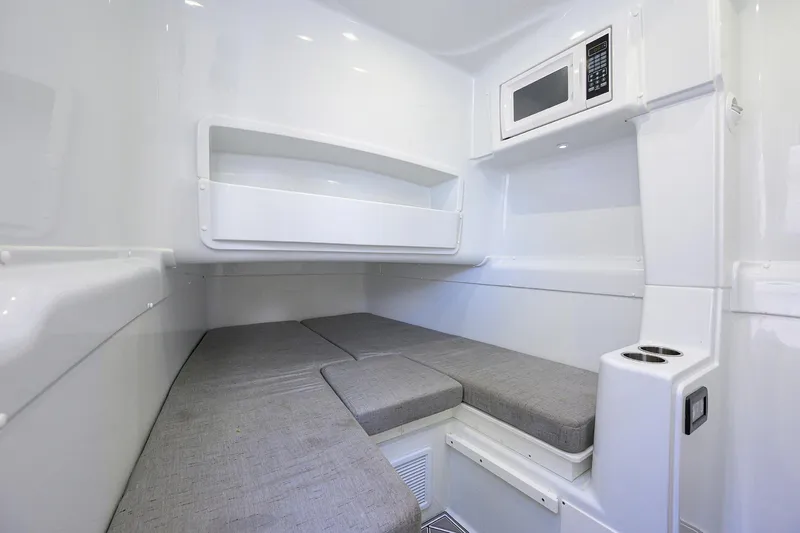 Denied Yacht Photos Pics 2021 Yellowfin 42 interior cabin with gray cushions and built-in microwave.