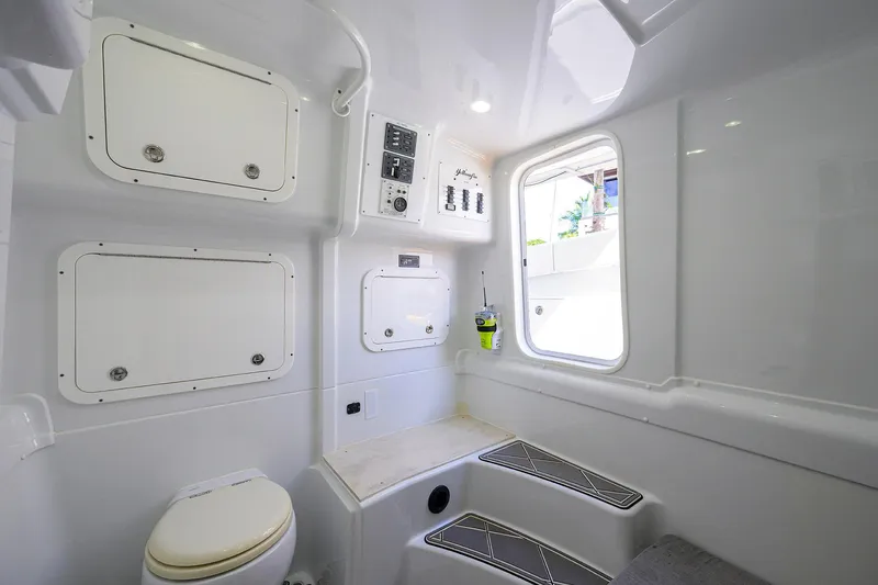 Denied Yacht Photos Pics 2021 Yellowfin 42 boat interior with white cabin, storage compartments, and a window.