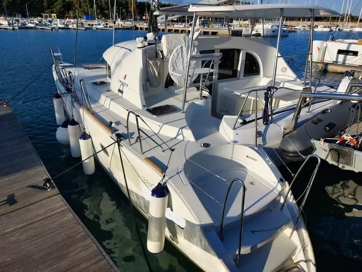  Yacht Photos Pics 2019 Lagoon 380 catamaran docked at marina, featuring spacious deck and modern design.