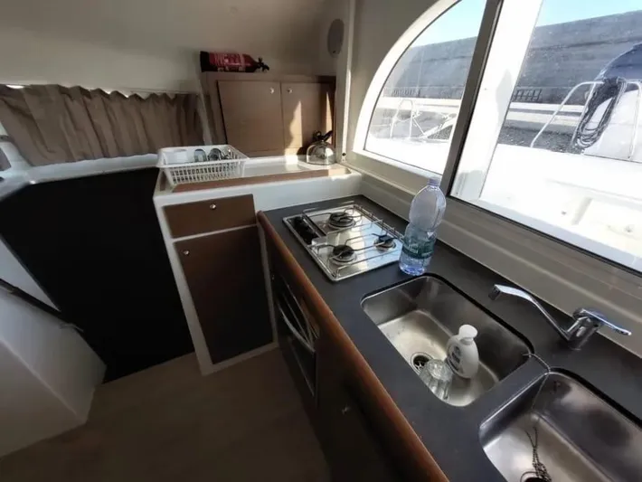 Yacht Photos Pics 2019 Lagoon 380 yacht kitchen with stove, sink, and window view.