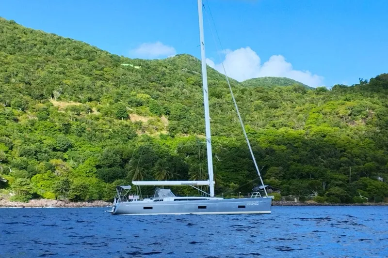 Ibubi Yacht Photos Pics Sailing yacht Grand Soleil 54 (2010) on blue water near lush green hills.