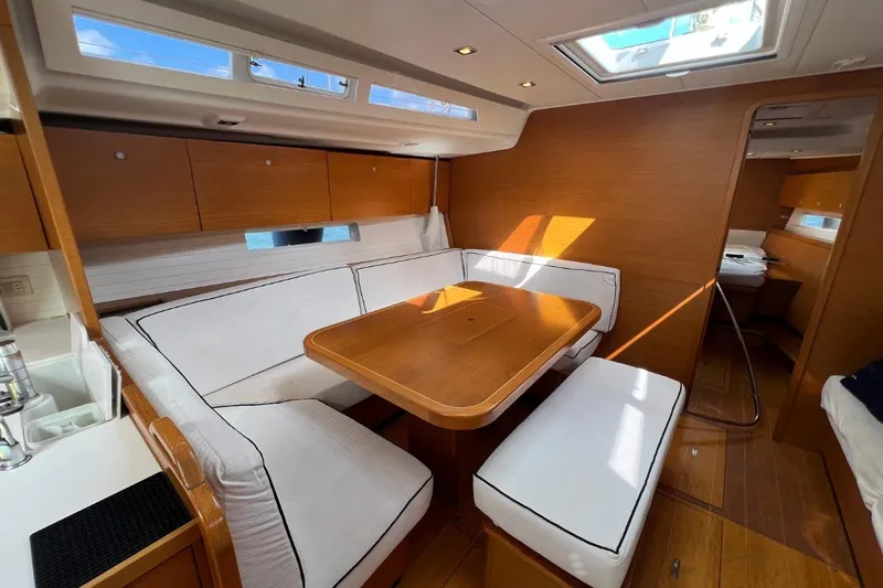 Ibubi Yacht Photos Pics Interior of 2010 Grand Soleil 54 yacht with wooden dining area and white seating.