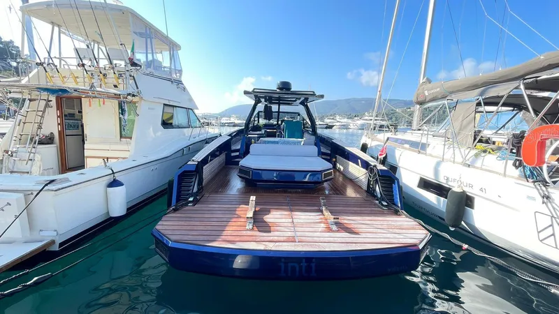  Yacht Photos Pics 2022 Evo Yachts R4 WA docked between boats, showcasing sleek design and spacious deck.