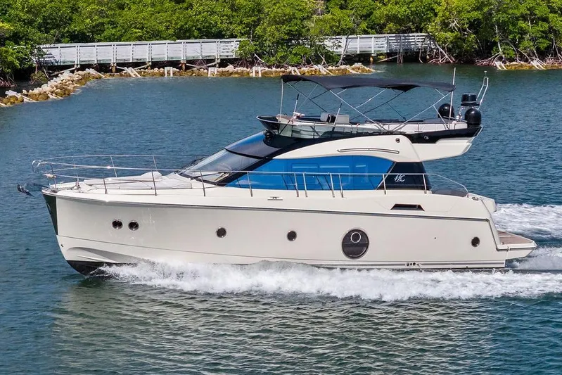  Yacht Photos Pics 2018 Monte Carlo MC 35 yacht cruising on a serene waterway with lush greenery.