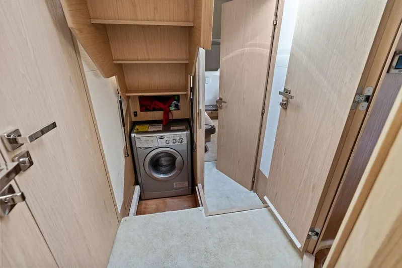  Yacht Photos Pics Laundry area inside 2018 Monte Carlo MC 35 yacht, featuring a compact washing machine.