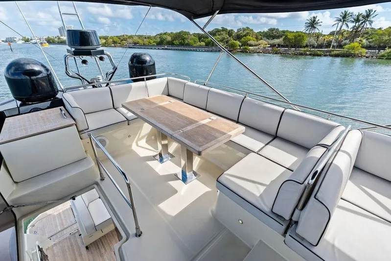  Yacht Photos Pics Luxurious 2018 Monte Carlo MC 35 yacht deck with seating and table, overlooking serene waterway.
