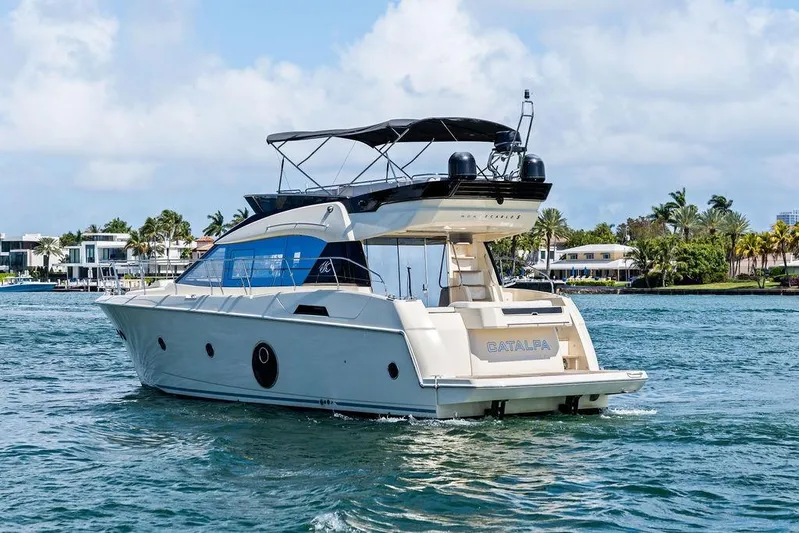  Yacht Photos Pics 2018 Monte Carlo MC 35 yacht cruising on a sunny day near luxury waterfront homes.