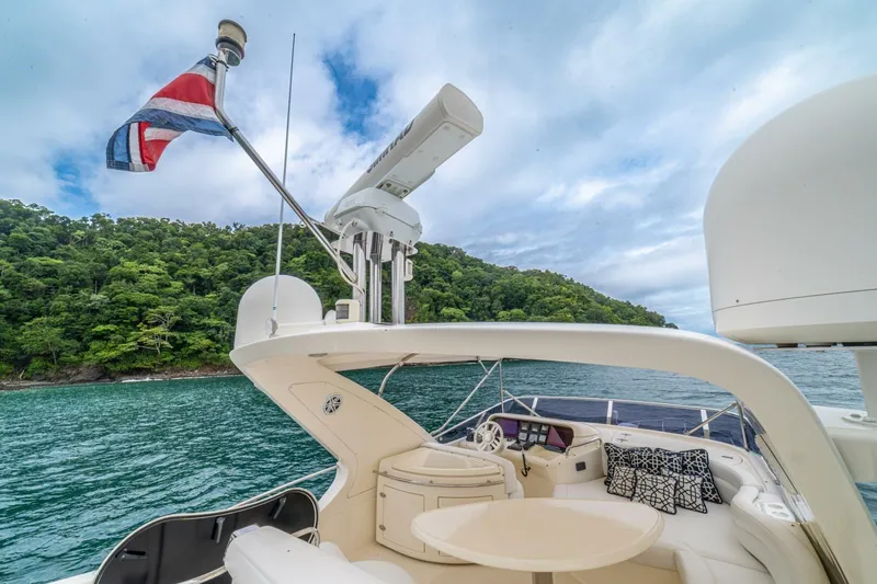 Hakuna Matata Yacht Photos Pics Luxurious 2007 Azimut 55 yacht with scenic ocean and lush green island backdrop.