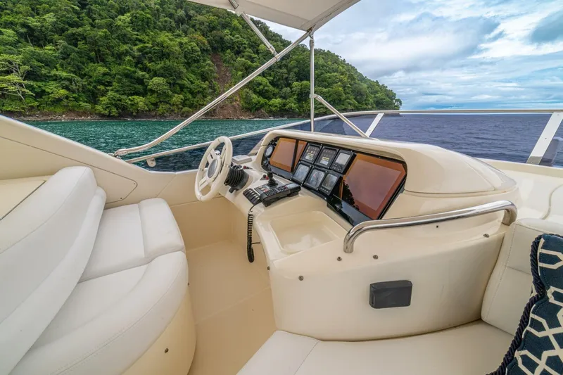 Hakuna Matata Yacht Photos Pics Luxurious 2007 Azimut 55 yacht helm with scenic ocean and lush greenery backdrop.