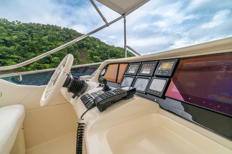 Hakuna Matata Yacht Photos Pics Cockpit view of 2007 Azimut 55 yacht with navigation controls and scenic ocean backdrop.