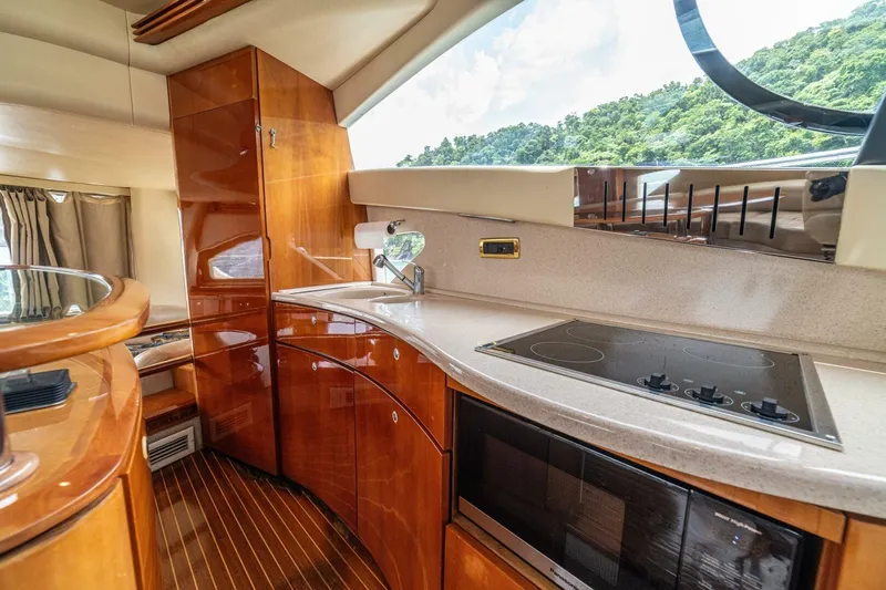 Hakuna Matata Yacht Photos Pics Luxurious 2007 Azimut 55 yacht kitchen with sleek wood cabinetry and modern appliances.