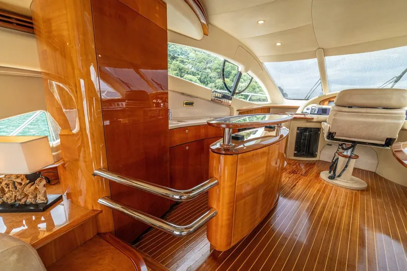 Hakuna Matata Yacht Photos Pics Luxurious interior of 2007 Azimut 55 yacht with polished wood and modern helm.