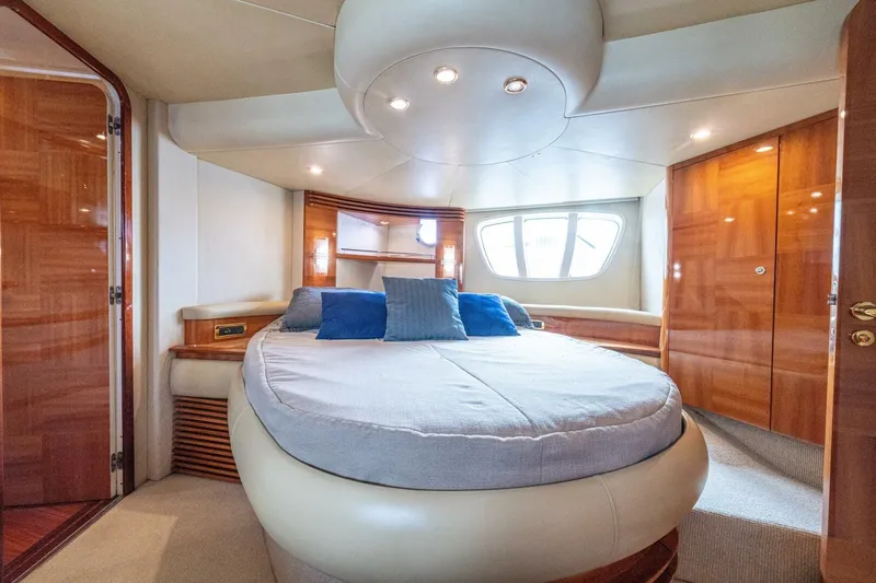 Hakuna Matata Yacht Photos Pics Luxurious bedroom interior of a 2007 Azimut 55 yacht with elegant wood finishes.