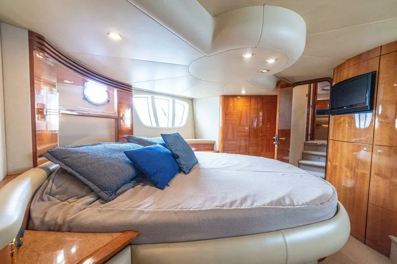 Hakuna Matata Yacht Photos Pics Luxurious bedroom interior of a 2007 Azimut 55 yacht with elegant wood finishes.