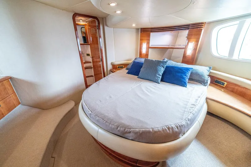 Hakuna Matata Yacht Photos Pics Luxurious bedroom interior of 2007 Azimut 55 yacht with plush bedding and elegant wood finishes.