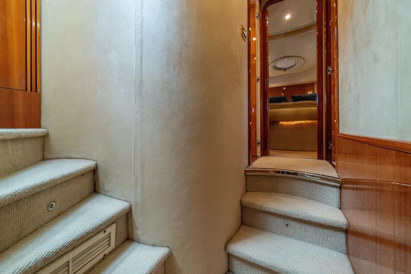 Hakuna Matata Yacht Photos Pics Interior staircase of 2007 Azimut 55 yacht, featuring elegant wood and carpeted steps.