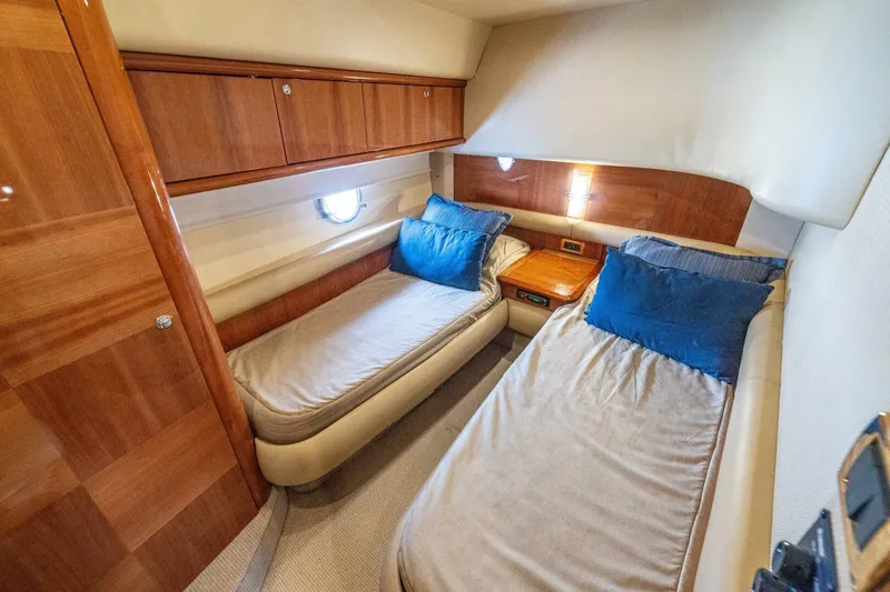 Hakuna Matata Yacht Photos Pics Luxurious twin cabin interior of 2007 Azimut 55 yacht with wooden finishes and blue pillows.