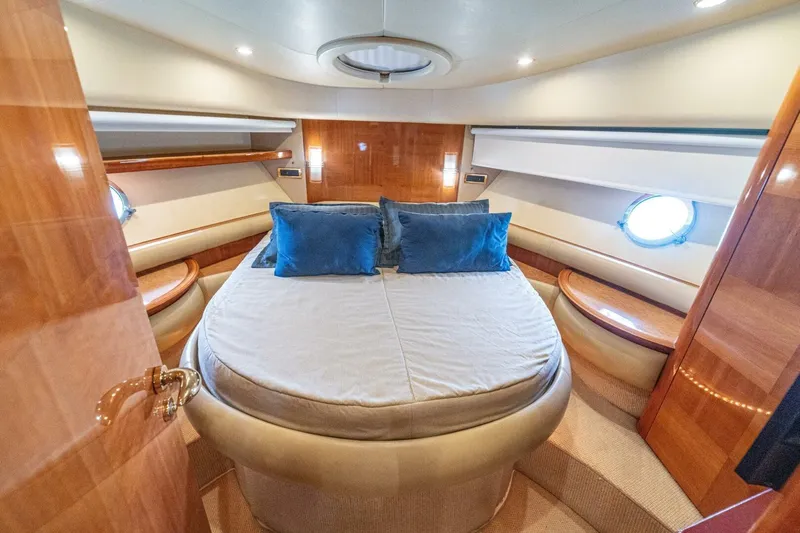 Hakuna Matata Yacht Photos Pics Luxurious bedroom interior of 2007 Azimut 55 yacht with round bed and porthole windows.