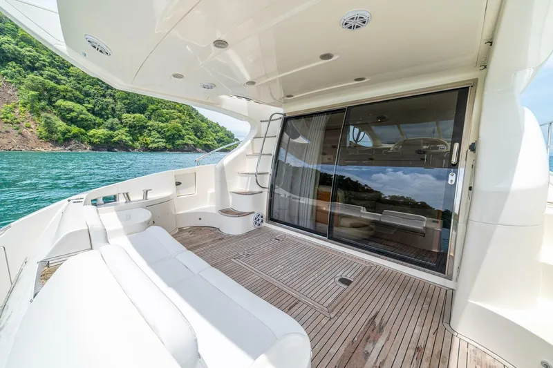 Hakuna Matata Yacht Photos Pics Luxurious 2007 Azimut 55 yacht deck with scenic ocean and lush greenery backdrop.