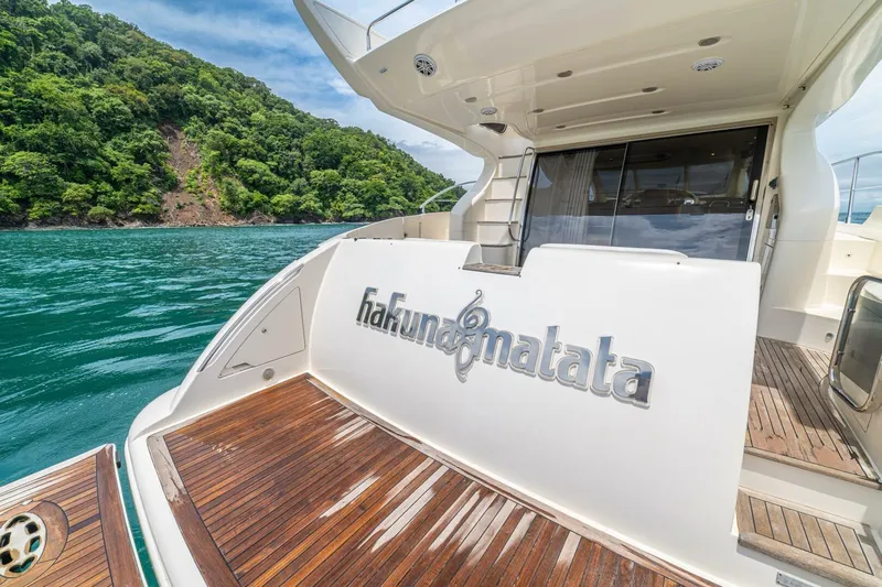Hakuna Matata Yacht Photos Pics Luxury 2007 Azimut 55 yacht with "Hakuna Matata" name, docked near lush green island.