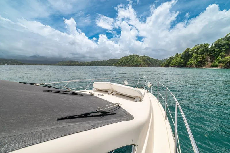 Hakuna Matata Yacht Photos Pics 2007 Azimut 55 yacht cruising in scenic tropical waters under a partly cloudy sky.