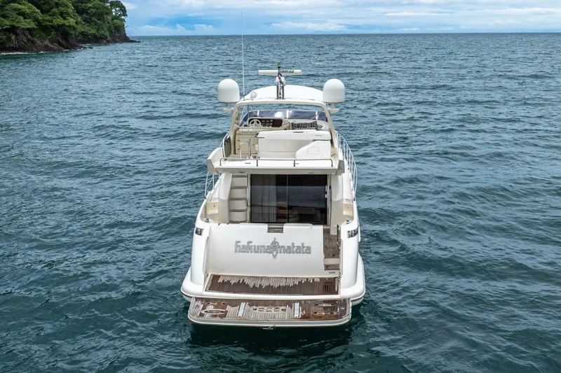 Hakuna Matata Yacht Photos Pics 2007 Azimut 55 yacht on open water, rear view with lush coastline.