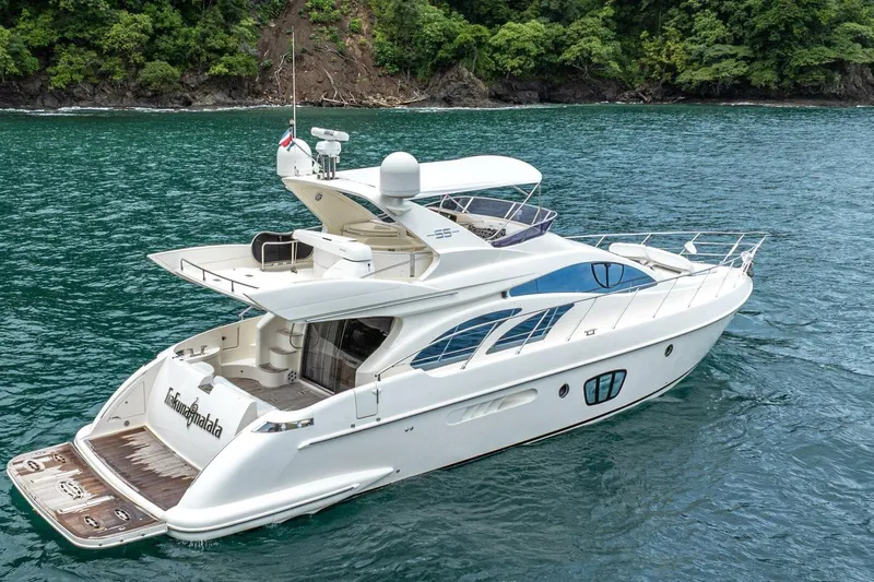 Hakuna Matata Yacht Photos Pics 2007 Azimut 55 yacht on serene water, surrounded by lush greenery.