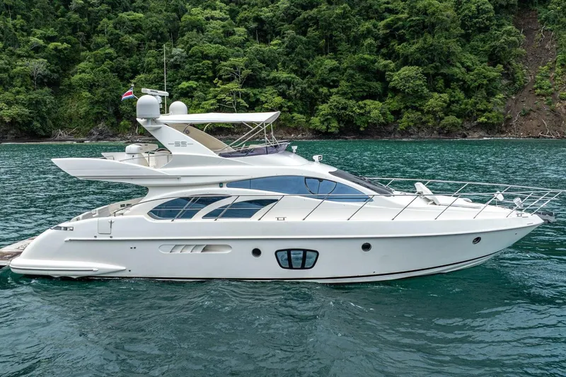Hakuna Matata Yacht Photos Pics Luxury 2007 Azimut 55 yacht cruising on serene waters near lush green coastline.