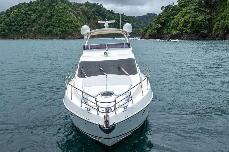 Hakuna Matata Yacht Photos Pics 2007 Azimut 55 yacht on serene water with lush green hills in the background.