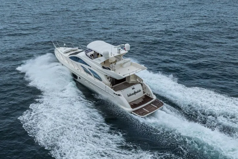 Hakuna Matata Yacht Photos Pics 2007 Azimut 55 yacht cruising on open water, creating a dynamic wake.