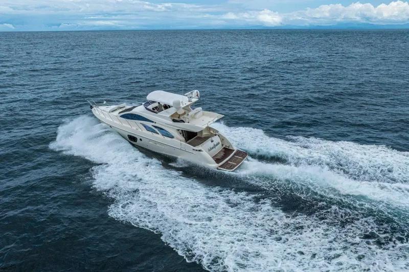 Hakuna Matata Yacht Photos Pics Luxury 2007 Azimut 55 yacht cruising on open sea under clear skies.