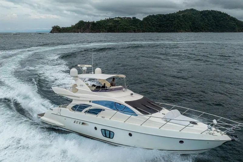 Hakuna Matata Yacht Photos Pics 2007 Azimut 55 yacht cruising on open water near lush island.