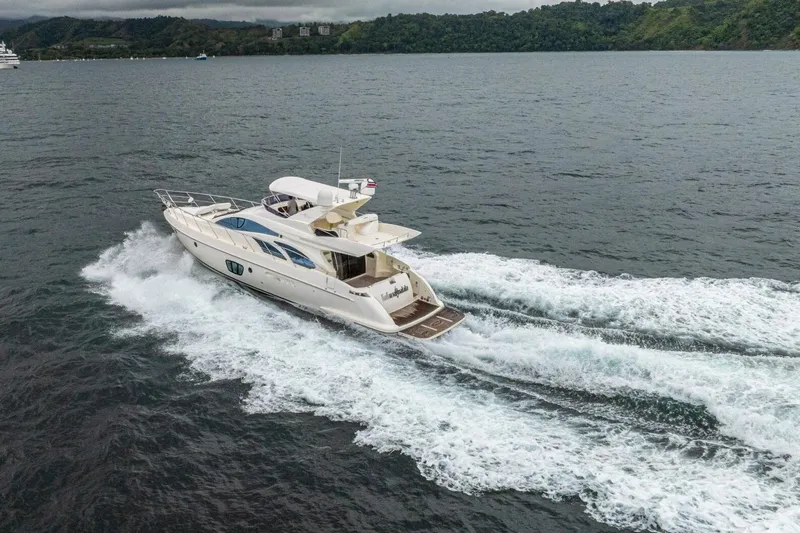 Hakuna Matata Yacht Photos Pics 2007 Azimut 55 yacht cruising on open water, surrounded by lush green hills.