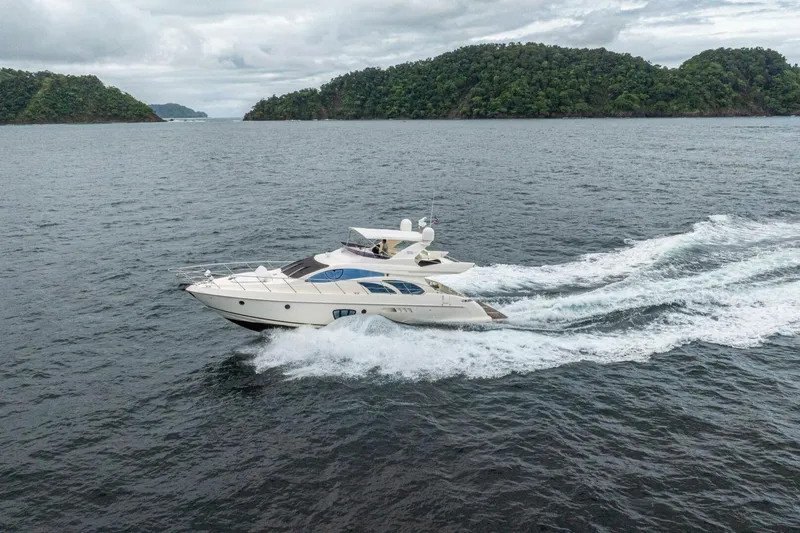 Hakuna Matata Yacht Photos Pics 2007 Azimut 55 yacht cruising on open water with lush islands in the background.