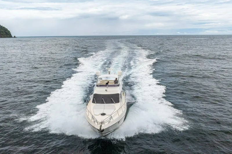 Hakuna Matata Yacht Photos Pics 2007 Azimut 55 yacht cruising on open sea, leaving a wake behind.