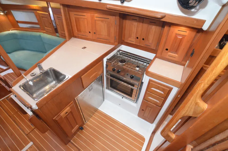 Tahlequah Yacht Photos Pics 2020 Tartan 365 yacht interior kitchen with wooden cabinets, sink, and stove.